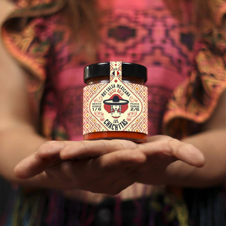 Las Chachitas Salsa Roja Glass in Händen